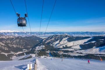 Fototapeta na wymiar Sunny Weather Over the Ski Slope and Panorama of Snow-Capped Mountains