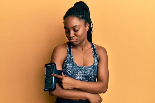 African american woman with braided hair wearing sportswear using arm band depressed and worry for distress, crying angry and afraid. sad expression.