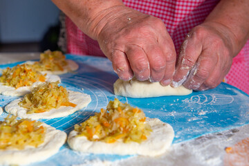 grandmother makes pies with cabbage from dough. High quality photo