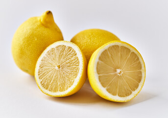  Two lemon fruit and halves isolated on a white background
