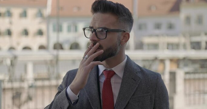 young handsome businessman smoking a cigarette like a boss