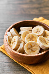 Fototapeta premium Photo of banana slices in a bowl on a wooden table
