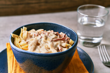  Bowl of fettuccine italian pasta with carbonara sauce on a concrete surface