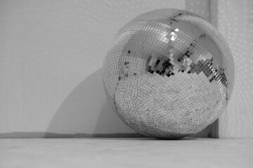 Large mirror disco ball on the floor in the club. Black and white photo.