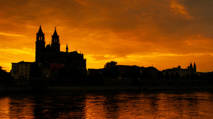 Silhouette of a medieval castle at beautiful bloody sunset at historical downtown of Magdeburg, old...