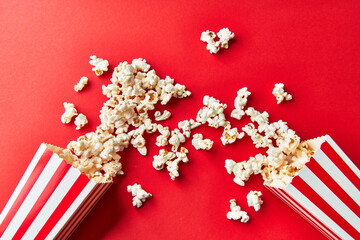  Two packs of salty popcorns falling on a red background