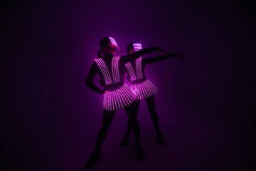 Two sexy disco dancers move in UV costumes. Parties and dances.