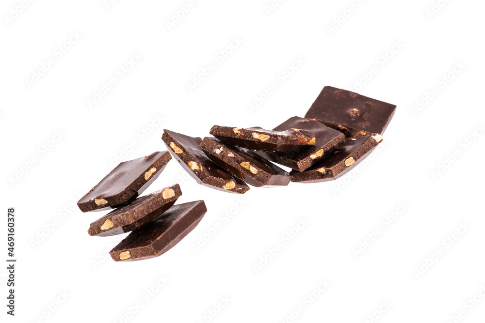 Poster pieces of dark chocolate with nuts in a heap isolated on white background