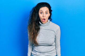 Fototapeta premium Young hispanic woman wearing casual clothes scared and amazed with open mouth for surprise, disbelief face