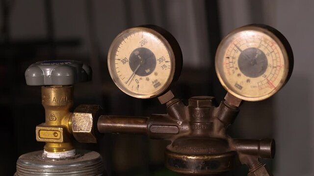 Welding equipment. Acetylene, argon or oxygen gas cylinder tank with gauge regulators manometers. Close up view.