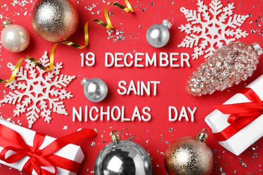 Text 19 December Saint Nicholas Day and festive decor on red background, flat lay