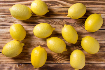 Ripe yellow lemons on a wooden background.