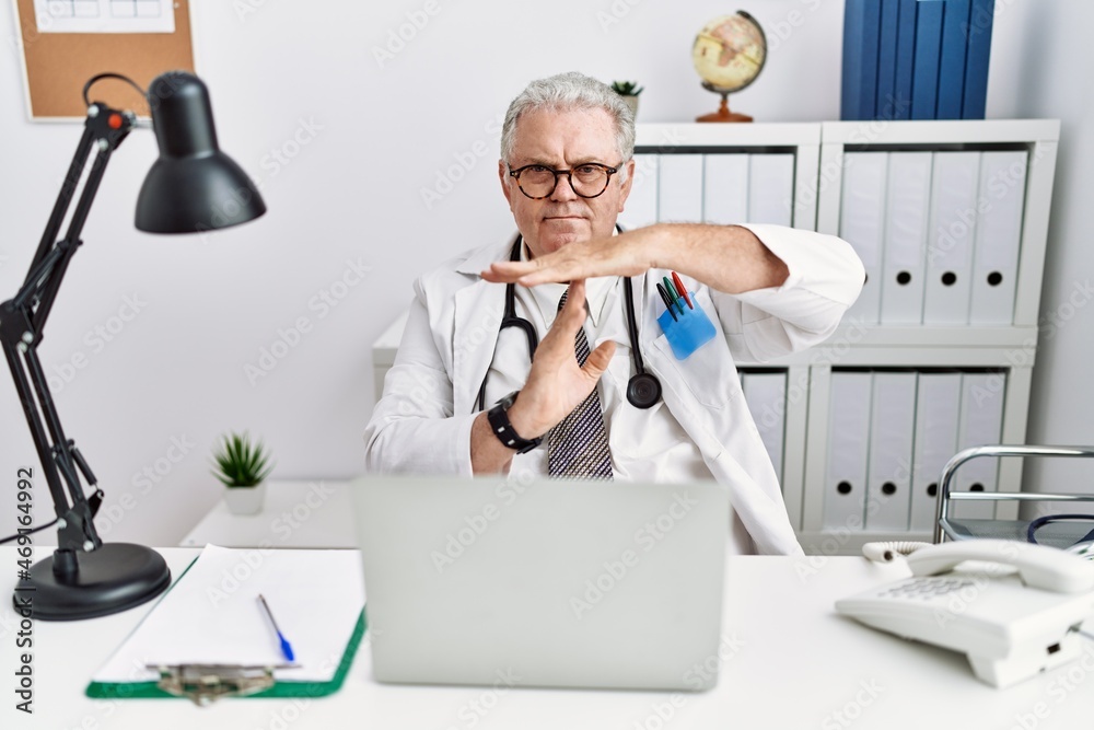 Sticker senior caucasian man wearing doctor uniform and stethoscope at the clinic doing time out gesture wit