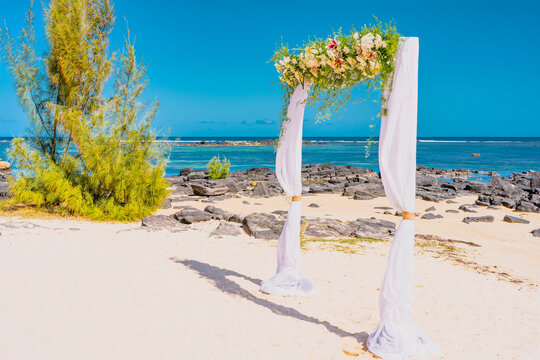 Wedding arch of flowers on the sky background, wedding ceremony of a tropical beach. High quality photo