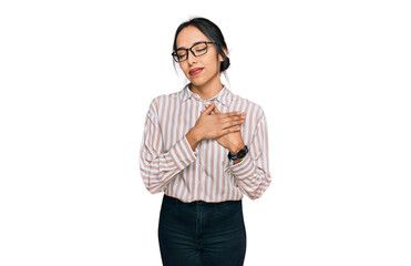 Young hispanic girl wearing casual clothes and glasses smiling with hands on chest with closed eyes and grateful gesture on face. health concept.