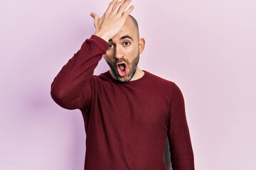 Obraz premium Young bald man wearing casual clothes surprised with hand on head for mistake, remember error. forgot, bad memory concept.