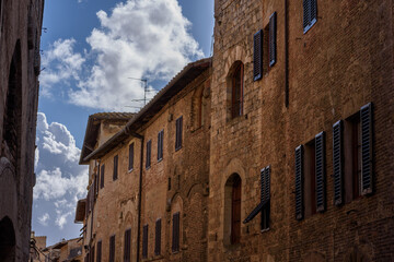 Fototapeta na wymiar Geschlechtertürme in San Gimignano, Toskana, bei Himmel und Wolken mit Sonnenschien