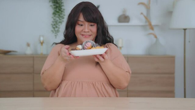 Overweight  young fat woman eat donut to sweet food is junk food. Obesity of a female with an appetite while being overweight., appetite control, dieting and health care concept.