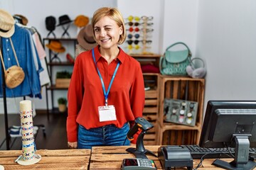 Middle age blonde woman working working as manager at retail boutique winking looking at the camera with sexy expression, cheerful and happy face.
