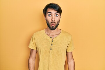 Fototapeta premium Young hispanic man wearing casual clothes scared and amazed with open mouth for surprise, disbelief face