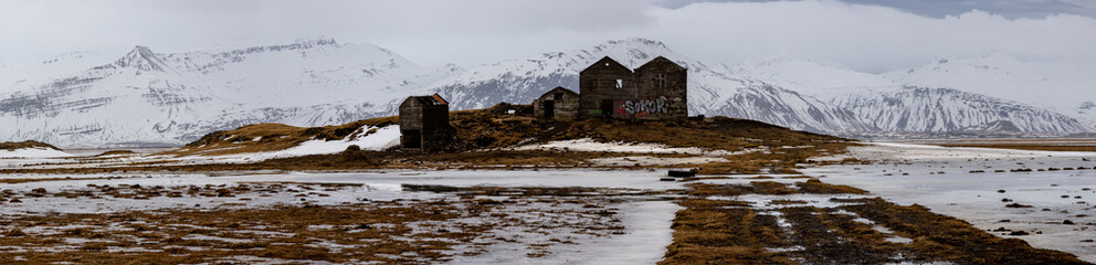 Fototapeta na wymiar Derelict farm and snow on the mountains, Iceland