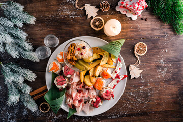 christmas antipasti dry cured meat on a plate on a table with fir tree