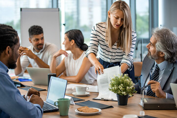 Multi-ethnic group of entrepreneurs discussing business. Finding solutions together. Multi-ethnic professionals are discussing while sitting at desk in office.