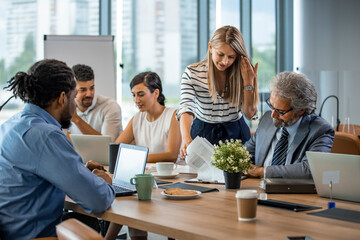 Group of people are working together in a modern working space. Cropped shot of a group of colleagues having a discussion in a modern office. Team of professionals having a new project meeting 