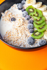 oatmeal bowl fruit breakfast vegetable milk, lactose free, banana, kiwi, berrie, blueberrie meal snack on the table copy space food background