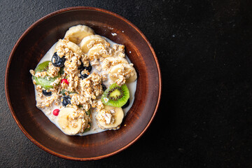 oatmeal bowl fruit breakfast vegetable milk, lactose free, banana, kiwi, berrie, blueberrie meal snack on the table copy space food background