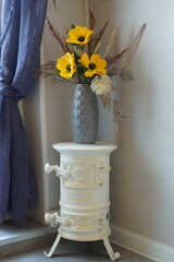 Beautiful bouquet of artificial flowers and  little stove