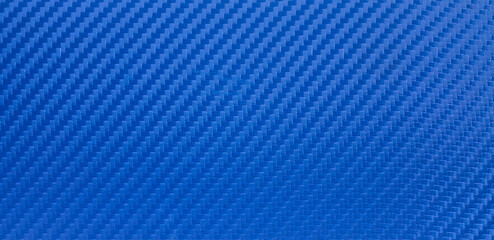 The texture of carbon fiber is blue. Blue background of vinyl film with carbon fiber texture. Rectangular banner for racing-themed text.