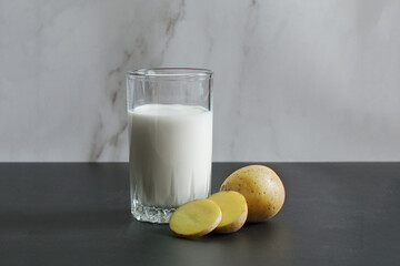 Vegan potato milk. Diet milk made from vegetables. A glass of milk and chopped potatoes. High...