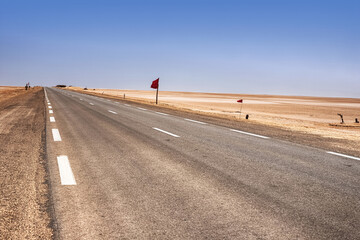 An asphalt road that runs along the Sahara Desert. Sahara Desert, Tunisia