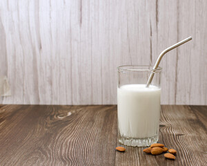 Vegan almond milk. Diet milk made from vegetables. A glass of milk and almond. The drink uses a reusable metal tube. Vegetarian diet and environmental protection concept. High quality photo