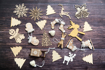 Obraz na płótnie Canvas Wooden handmade snowflake toys on dark wooden Christmas background. Crafts cut from eco friendly wood material. Ecological home decor for winter holiday. Copy space. Frame