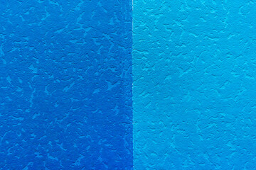 The surface of two shades of blue. Blank for design. Blue wallpaper with abstract pattern wall texture background