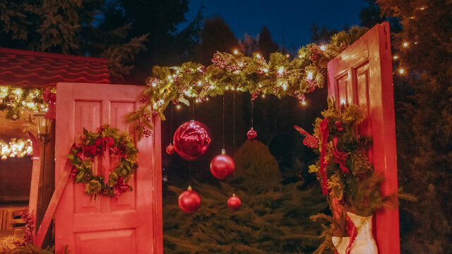 Beautiful house decorated for Christmas is about Christmas trees. Open the door of the house for Santa Claus. Christmas night. Christmas holiday wreath adorns front door to home.