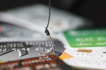 Fishing hook is hooked on plastic bank credit card closeup