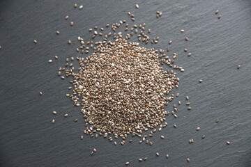 Seeds of Chia, Salvia hispanica, aromatic and medicinal plant, edible seeds, on grey background