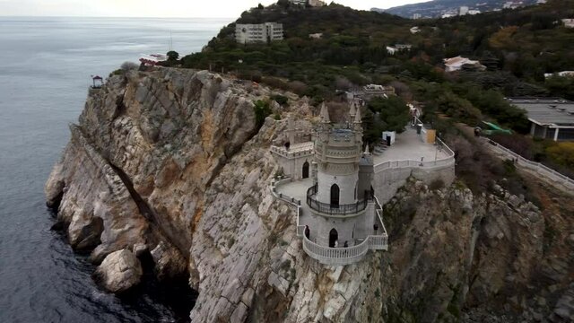 Flight around the Swallow's nest in Crimea 4k video. The castle tower is on the edge of a high cliff. Black Sea background 
