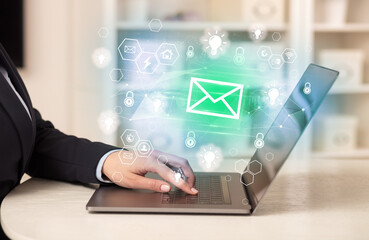 Hands working on laptop with digital icons