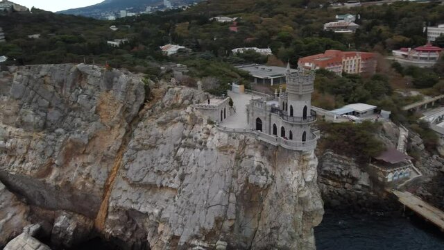 Flight around the Swallow's nest in Crimea 4k video. The castle tower is on the edge of a high cliff. Black Sea background 