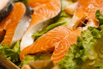 Salmon steaks with lettuce close-up. Fresh raw red fish.
