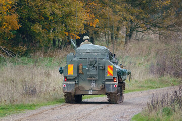 Fototapeta premium British army FV103 Spartan tracked armored reconnaissance vehicle heading away in action on a military exercise Salisbury Plain, Wiltshire UK
