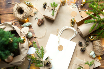 Gift Package for Christmas and new year in eco-friendly materials: kraft paper, live fir branches, cones, twine. Tags with mock up, natural decor, hand made, DIY. Copy space. Flatly, background