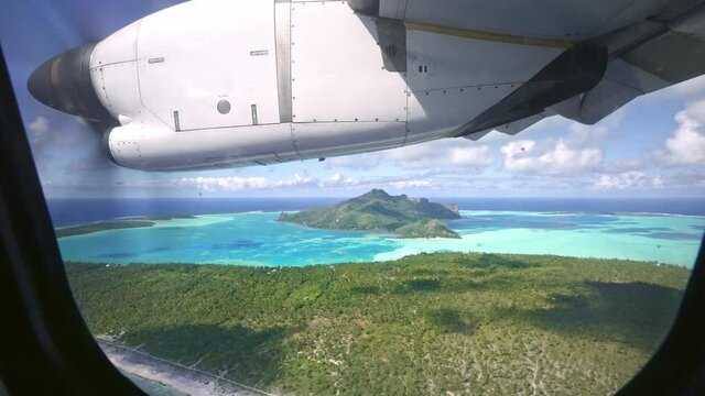Aerial view Tahiti drone Maupiti island, seen from the plane window. blue lagoon. French Polynesia. Tropical paradise island. Exotic travel vacation getaway, romantic honeymoon destination.