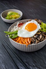 Traditional Korean dish - bibimbap , rice bowl with vegetables , egg and ground beef.