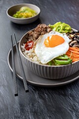Traditional Korean dish - bibimbap , rice bowl with vegetables , egg and ground beef.