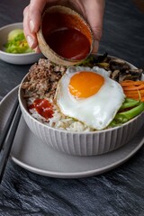 Traditional Korean dish - bibimbap , rice bowl with vegetables , egg and ground beef.